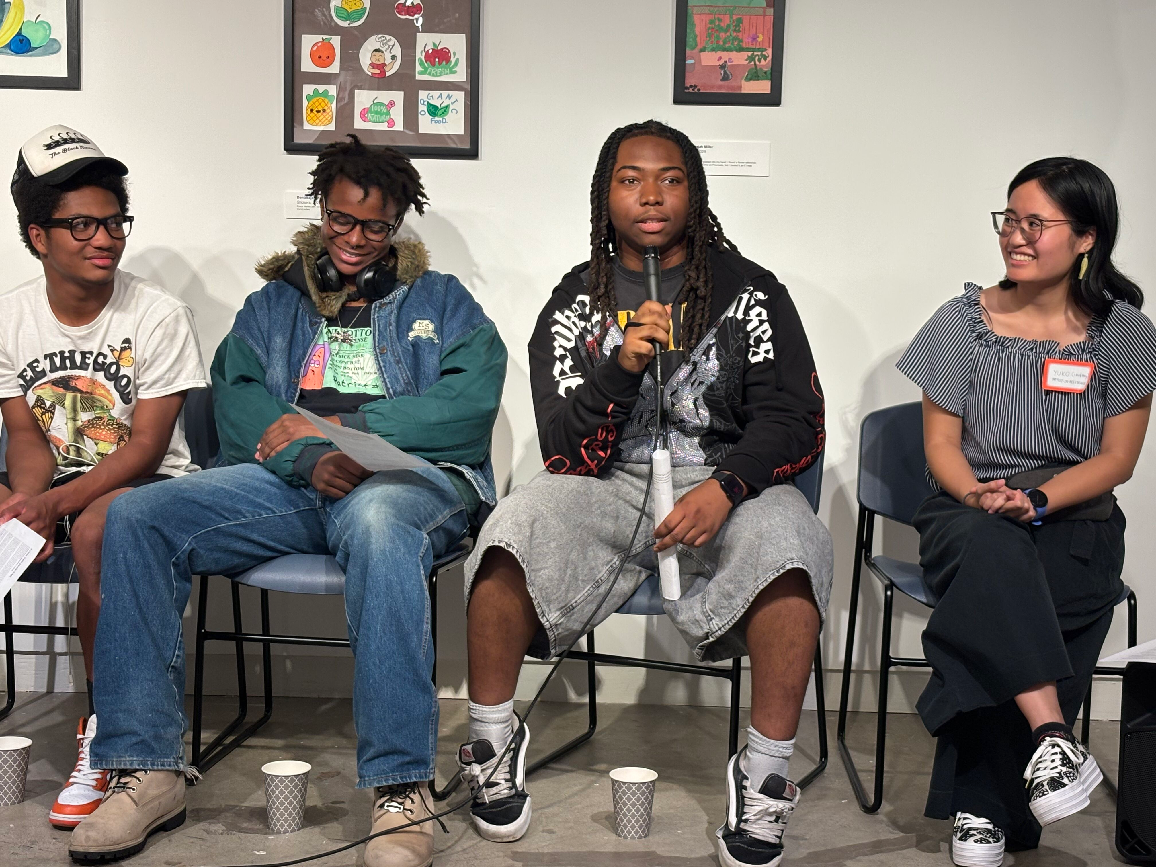 Three students and the Artist in Residence sit smiling at each other during an artist talk.