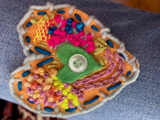Close-up of a heart made with felt and embroidered details by Hinda Mandell