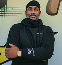 Rob Stull standing in front of a mural smiling.