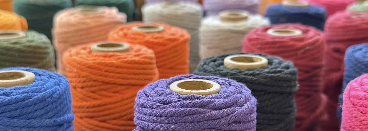 Many multicolored spools of yarn