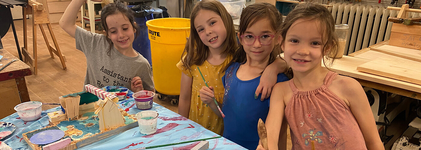 Four young students pose with their art project.