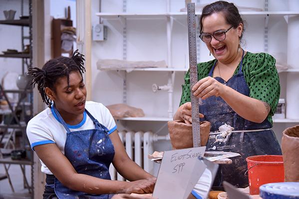 Art teacher and student working on project